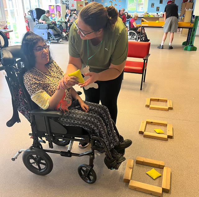 a woman in a wheelchair taking part in indoor sports