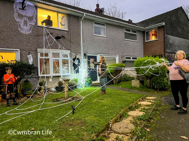 group of people decorate a house for halloween