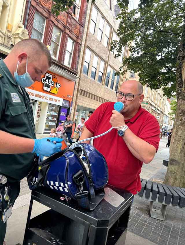 a man being given painkilling gas leaning on a bin