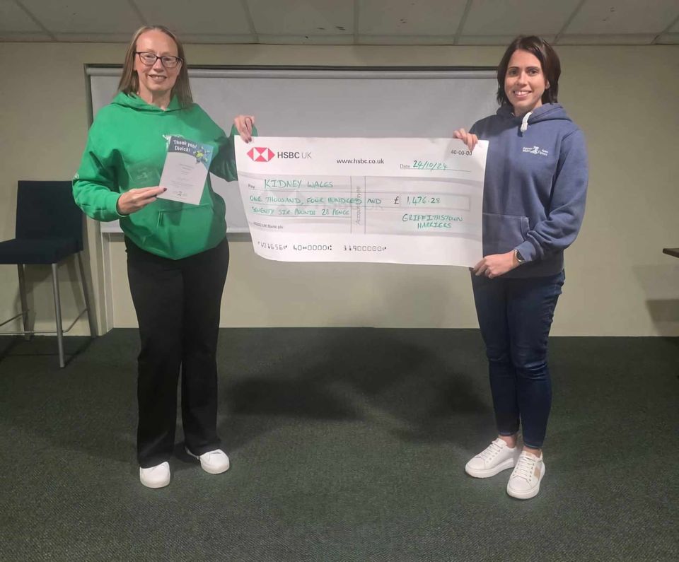 two women hold a large cheque