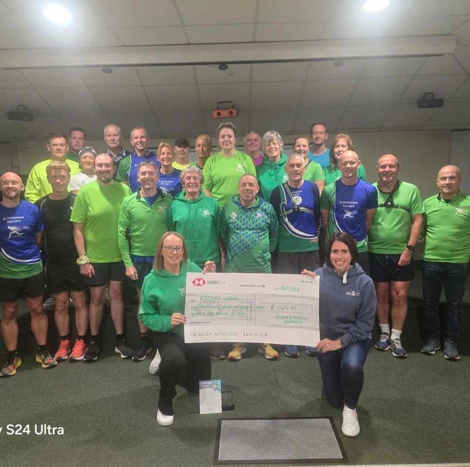 group of runners holding a cheque