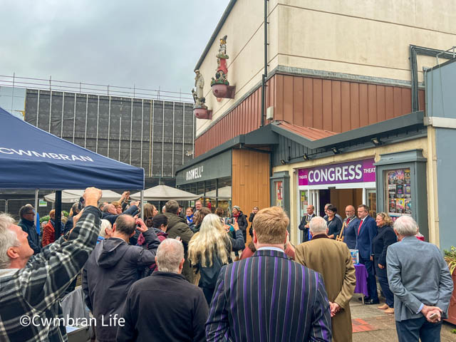 group of people outside a theatre have their photo taken