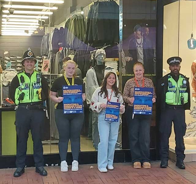 two police officers stood with staff at a shop