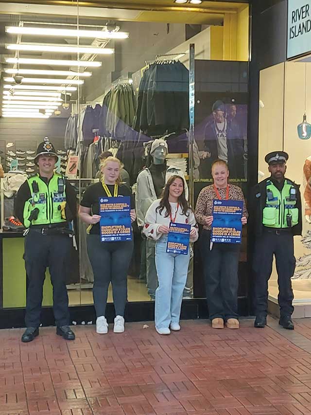 two police officers stood with staff at a shop