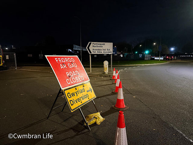 a road closed sign by a roundabout