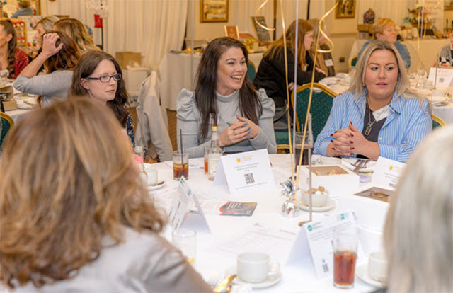 women at a table in a hotel room