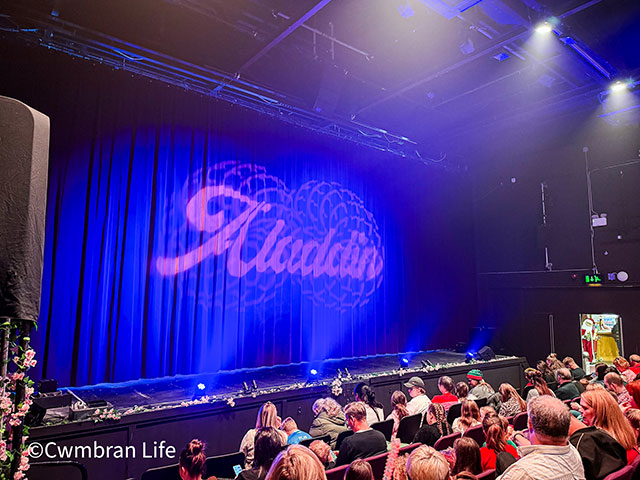 a theatre stage with Aladdin on the curtain