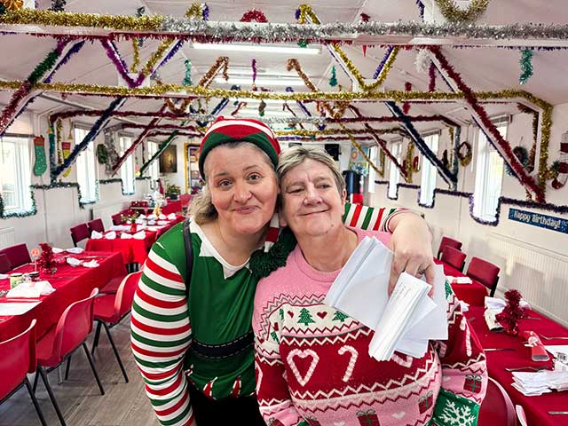 two women in christmas clothes in a hall