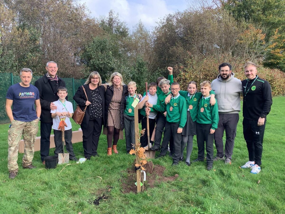 Pupils and staff plant an oak tree at Greenmeadow Primary School