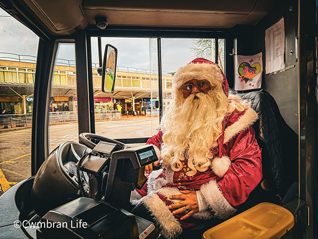 santa sat at front driver's seat on a bus