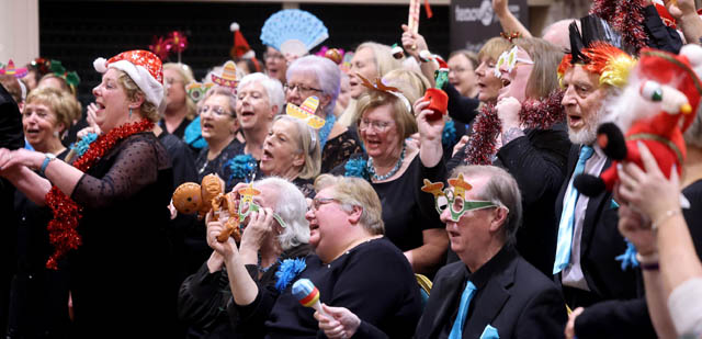 a choir wearing christmas hats and glasses