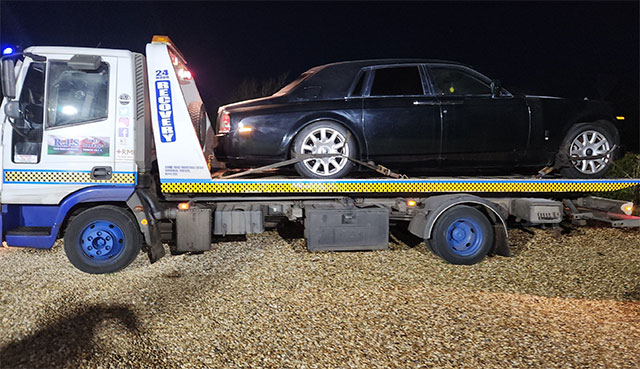 a flatbed lorry with a rolls royce on the back of it