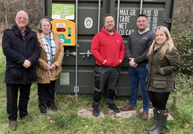 five people stood in front of a defibrillator