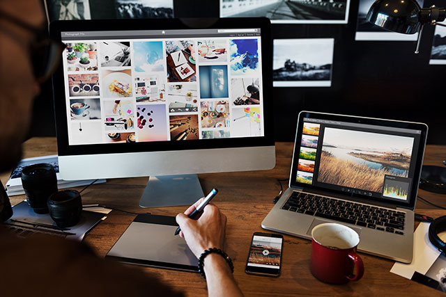 a person in front of a laptop and desktop