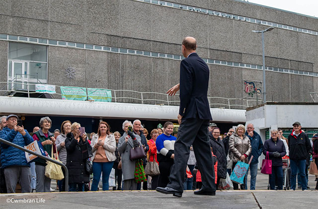 Prince Edward waves to shoppers