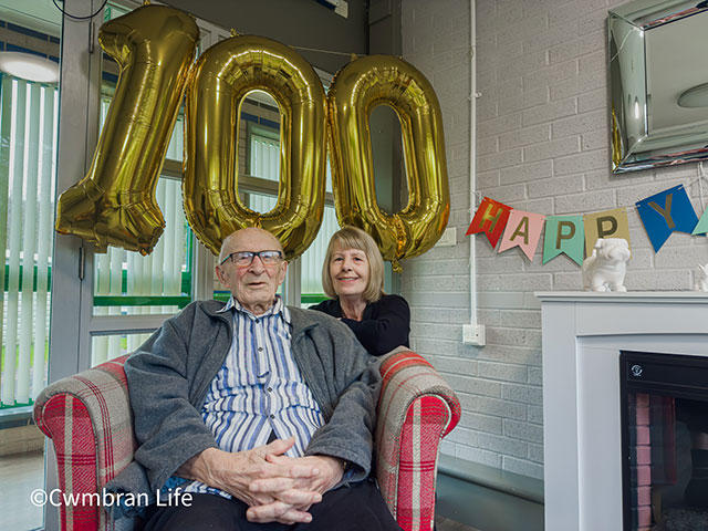 stan and denise by a 100th birthday balloon