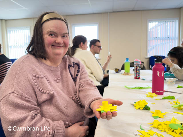 woman holding a daffodil made for arts and crafts calss