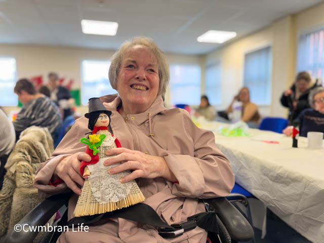 a woman holds a small welsh lady she's made