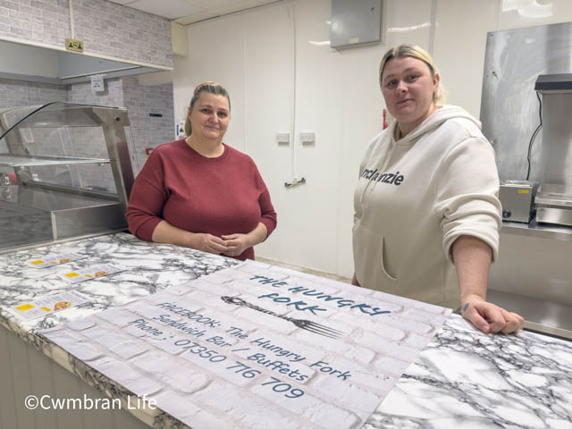 two women lean on a counter in a kitchen