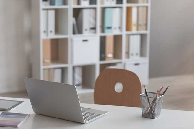 Close-up of laptop on desk at empty modern office