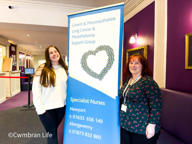 two women stood by a pop up banner