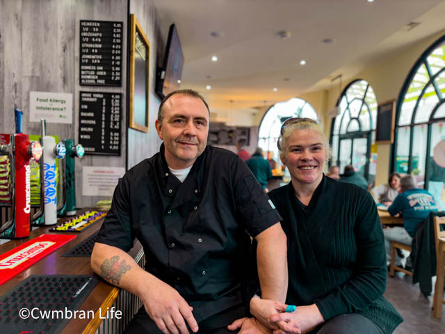 a man and woman sat at bar in cafe