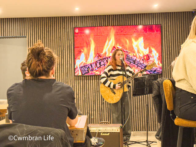 a woman singing and playing guitar