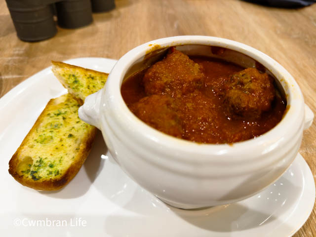 a beef meatballs in tomato sauce with garlic bread 