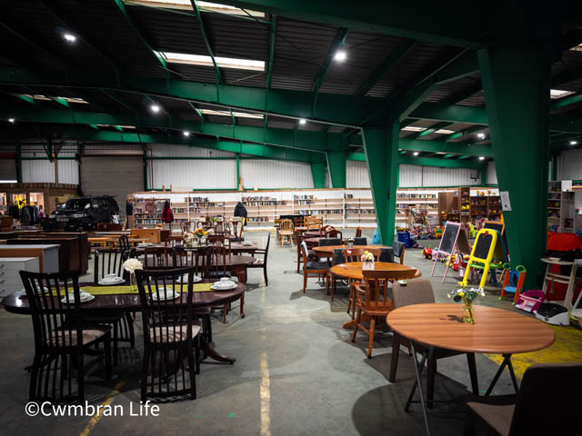 dozen of wooden table and chairs in a warehouse