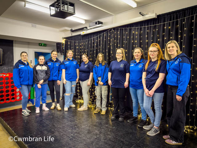 a group of staff and volunteers in a youth centre stood on a stage