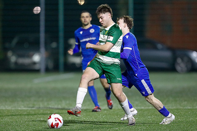 two footballers go for the ball