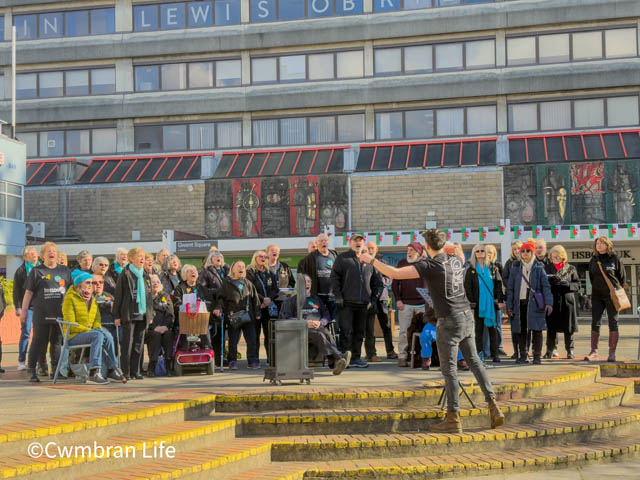 a choir singing outside in a town centre