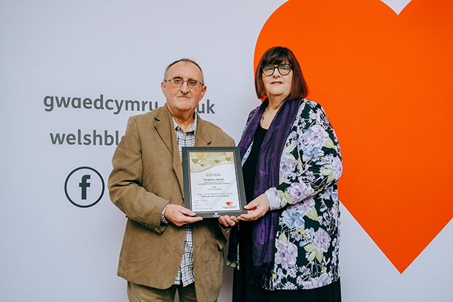 a woman presents a certificate to a man