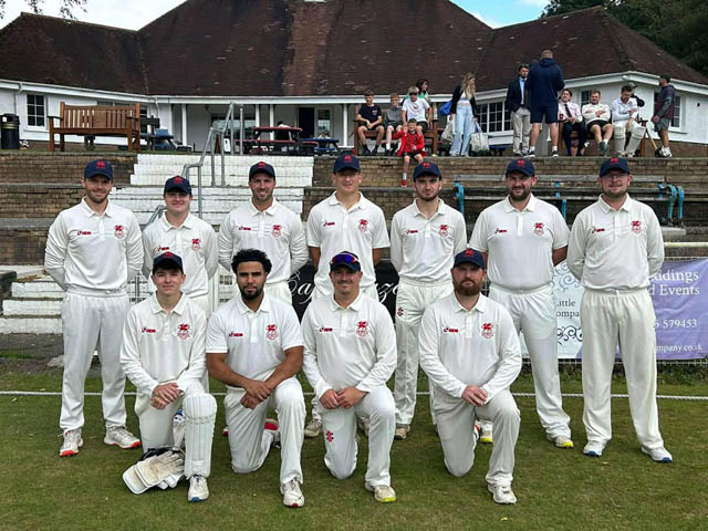 a team of male cricket players in their whites fro a team photo