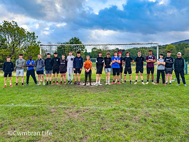 a football team stand in front of goal posts