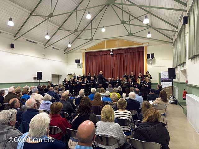 a choir performing to an audience in a church hall