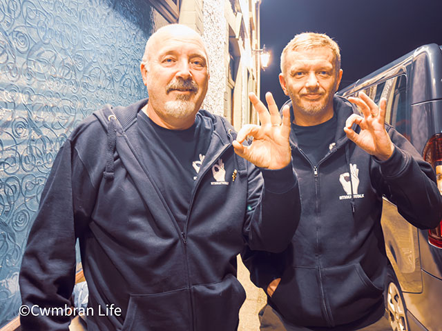 two men wearing andy's man club tops