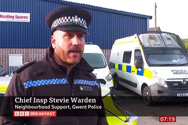 a police officer stood in front of a police van