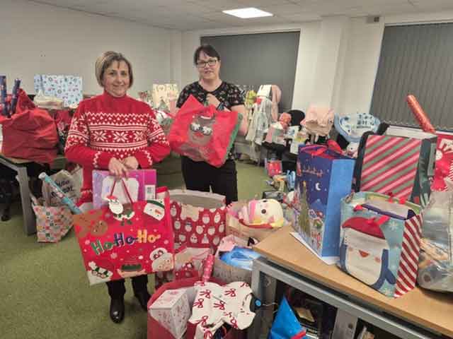 two women in a room surrounded by Christmas presents