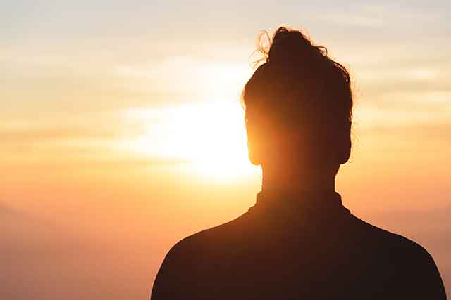 Male hiker observing the sunset at the top of the local big mountain