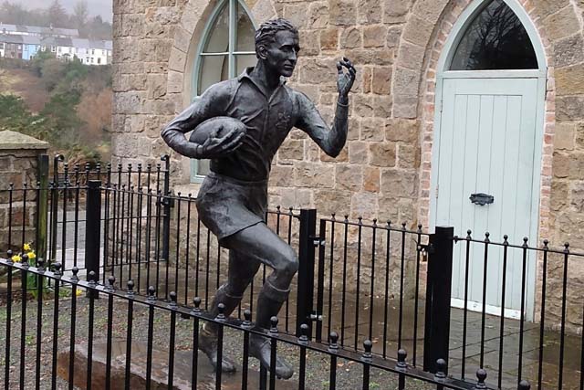 a statute of a man running with a rugby ball