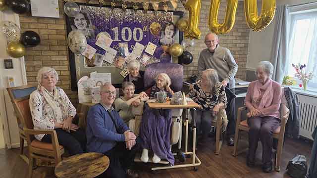 a woman celebrating her 100th birthday with family