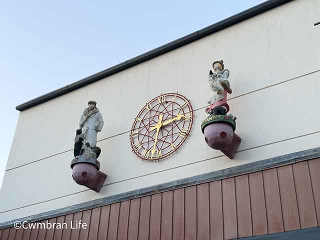 two statuettes on a. building overlooking a square