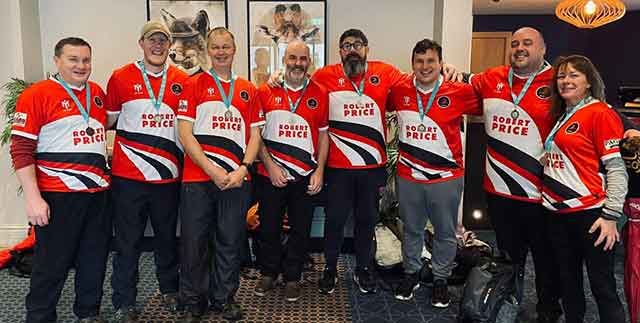 a rugby team stand and smile at the camera