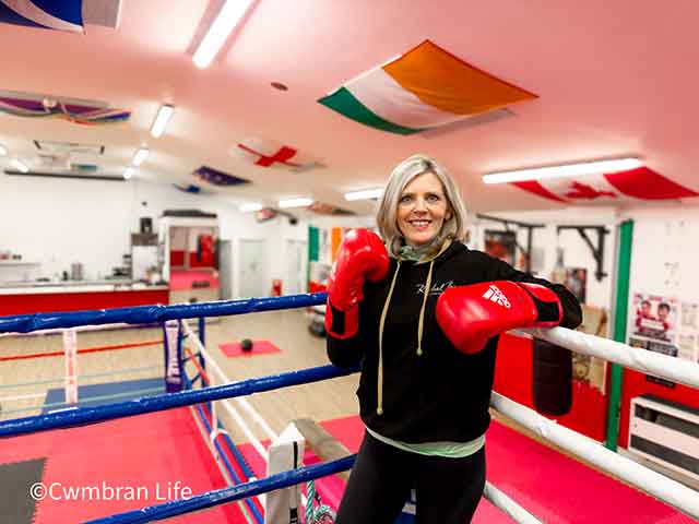 a woman in a boxing ring wearing red boxing gloves