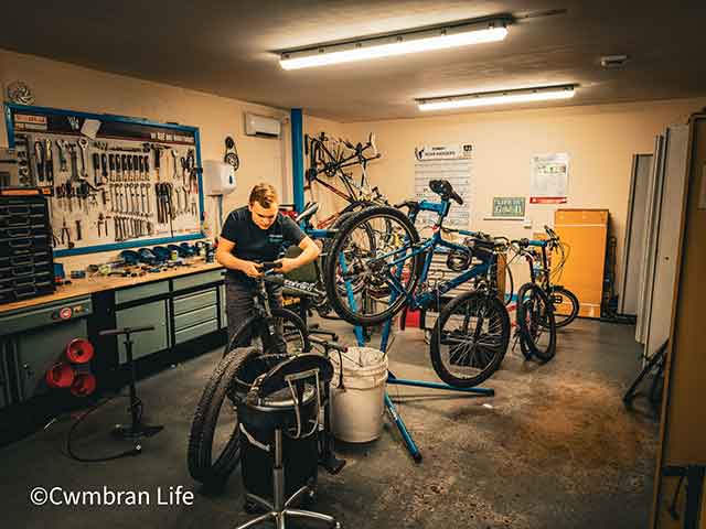 a teenage boy repairing a bicycle