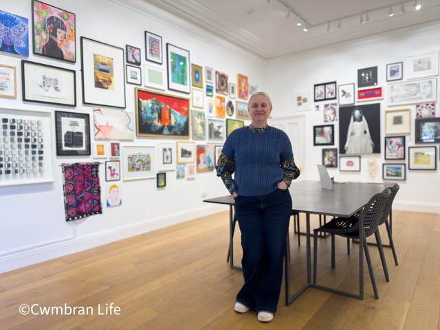 a woman stood in a gallery with artwork on the walls