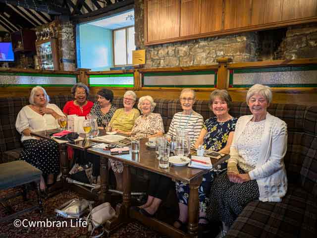 eight women, all aged in their 80s sat in row at table