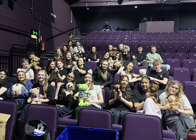 a large group of teenagers sat in a theatre