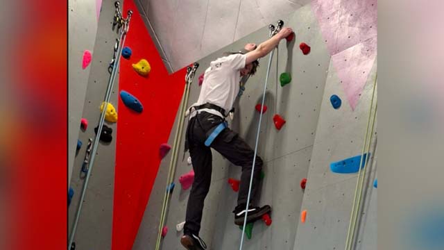 a teenage boy on a climbing wall